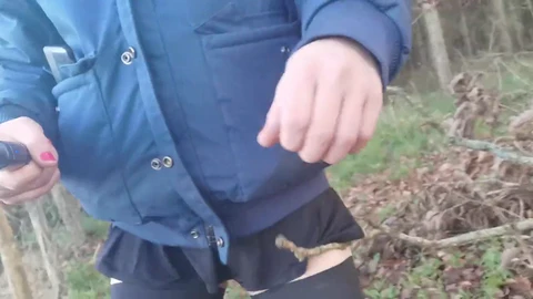 Crossdresser slut flaunts her assets in the woods wearing a tiny skirt thong and sky-high heels